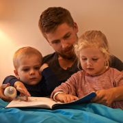 Father reading a bedtime story to his two children