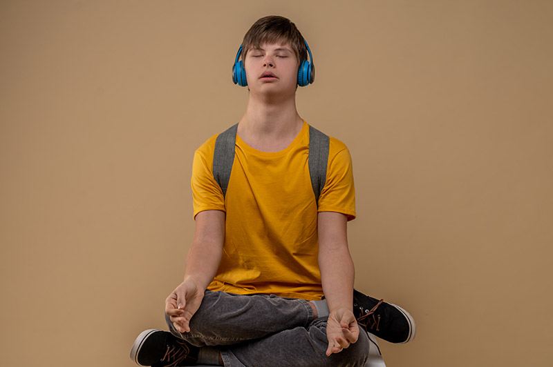 Teenager meditating wearing headphones