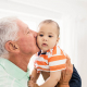 Grandparent carrying his grandchild