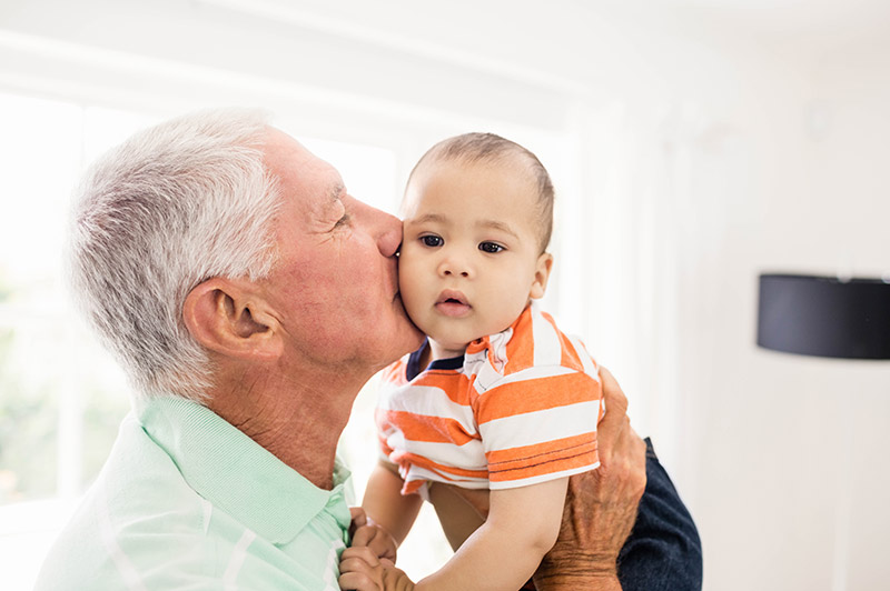 Grandparent carrying his grandchild