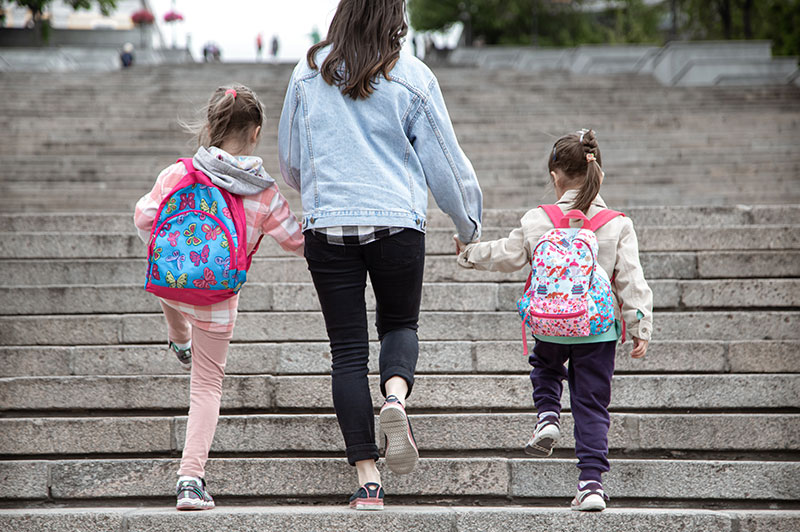 Mum with her two daughters walking up some steps