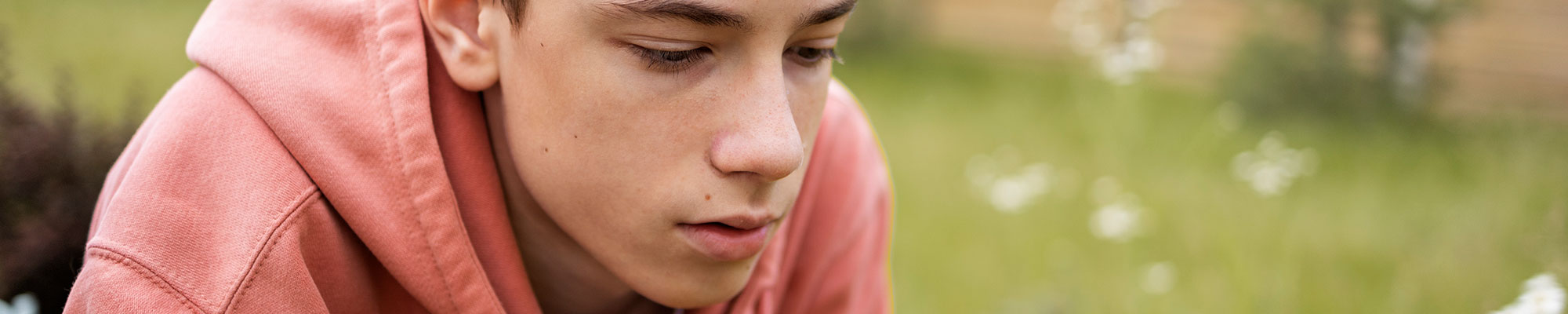 Teenage boy sat thinking outside