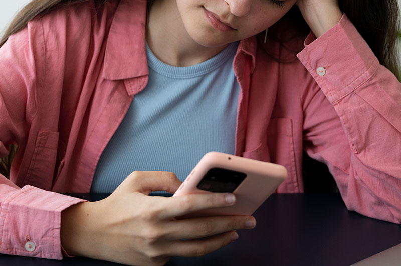 A teenage girl looking at her mobile phone